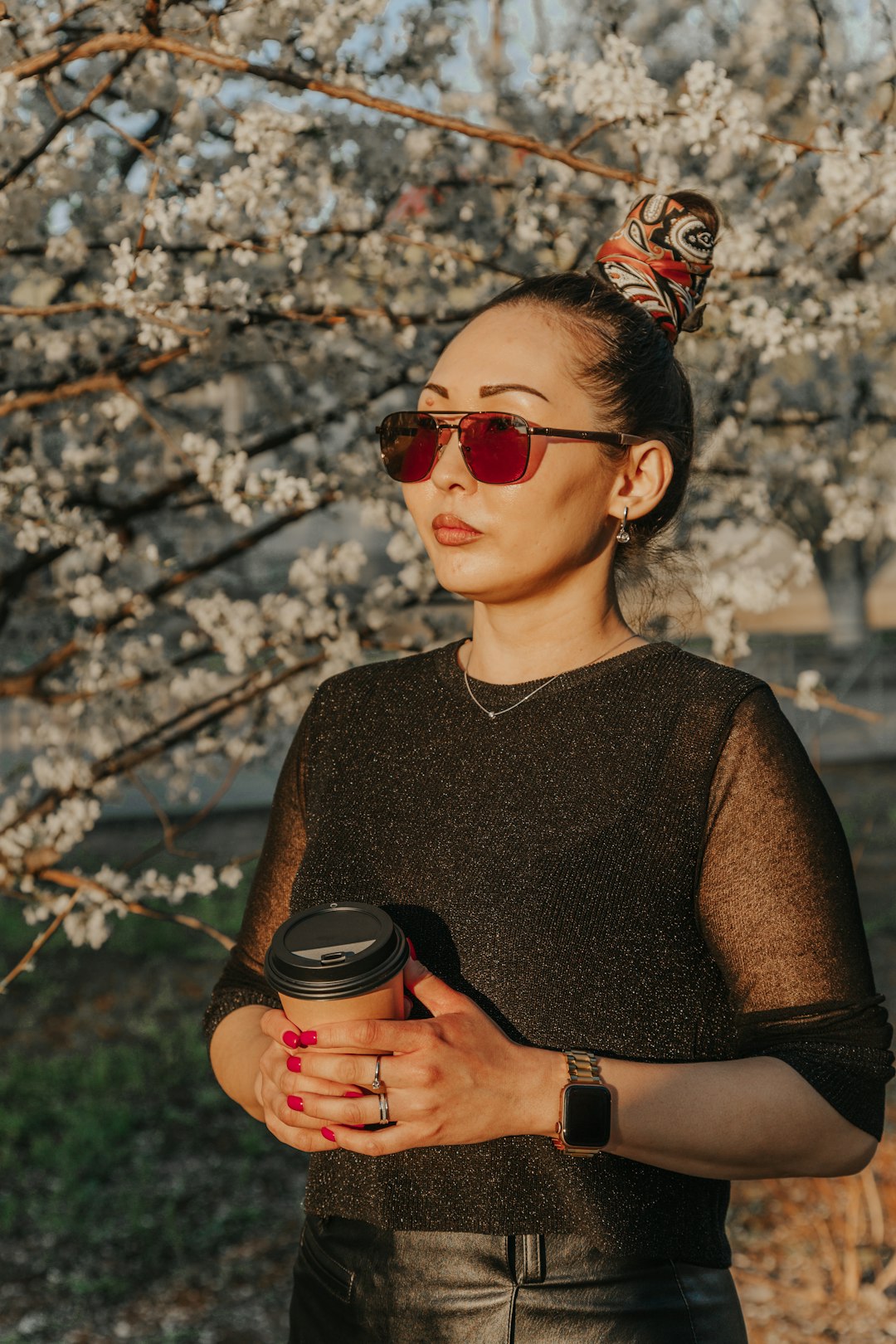 woman in black crew neck shirt holding black and red disposable cup