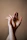 Two hands intertwined in a Chinese finger puzzle, capturing the tension and eventual ease of personal growth.