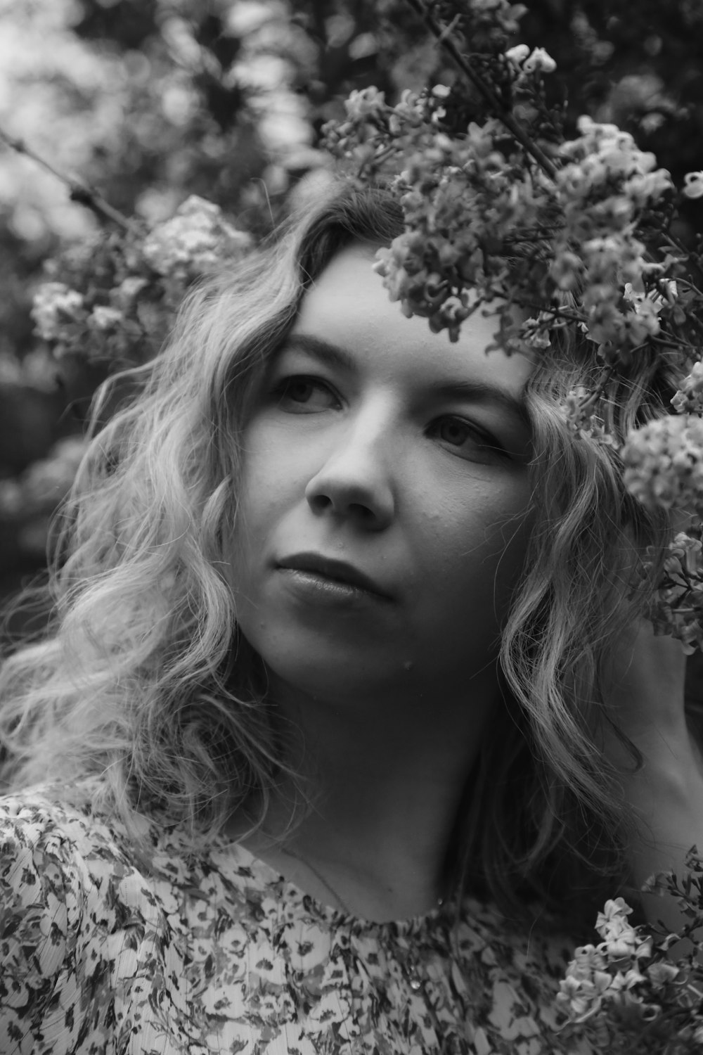 grayscale photo of girl with flower on her ear