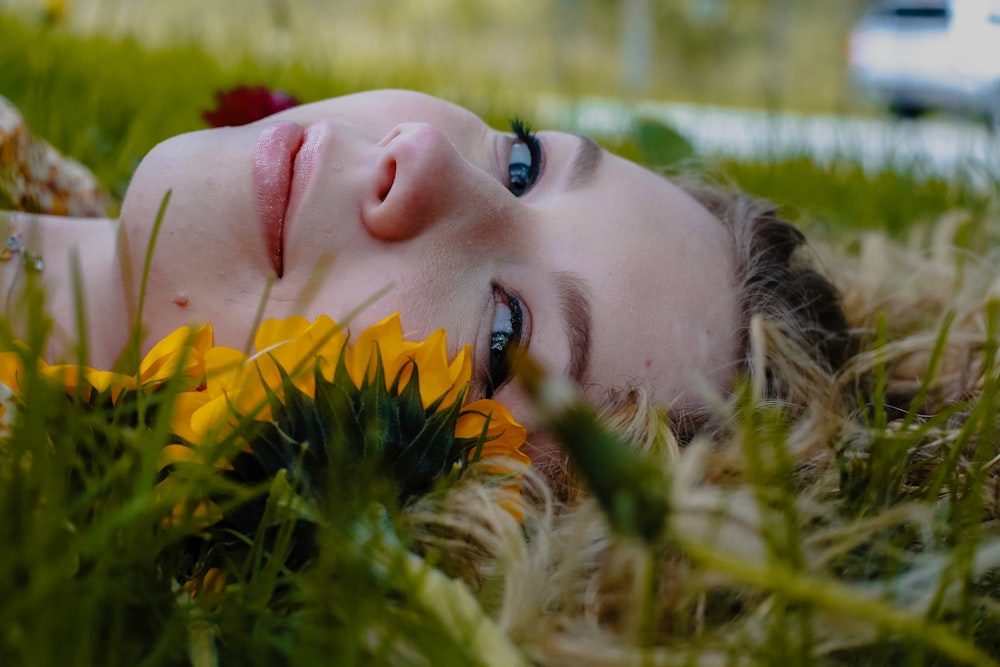 woman lying on green grass during daytime