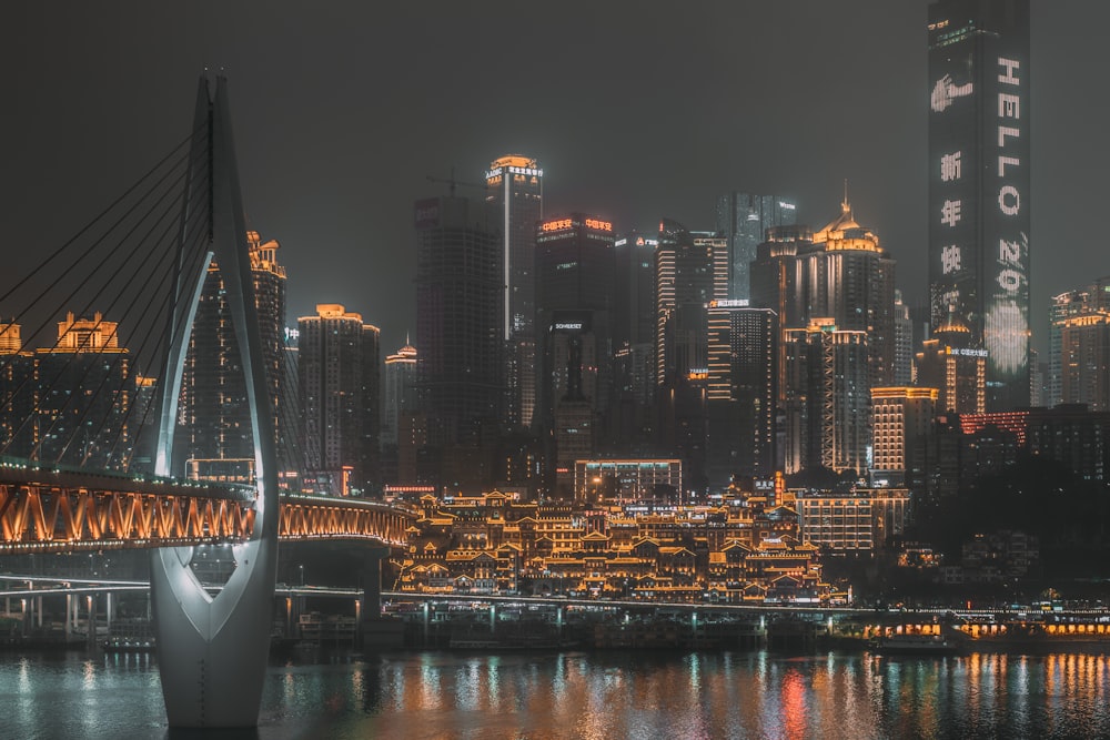 white boat on body of water near city buildings during night time