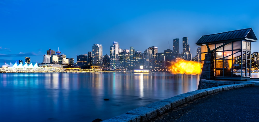 city skyline across body of water during night time