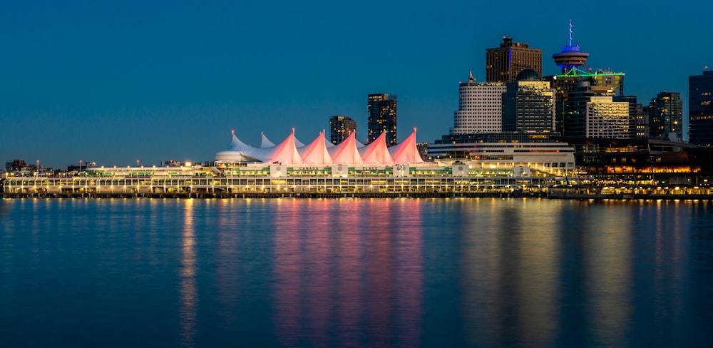 city skyline across body of water during night time