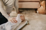 An infant engaged in gentle stretching exercises on a soft mat.