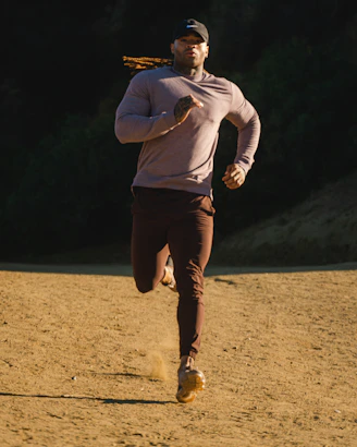 man in white long sleeve shirt and brown pants standing on brown field during daytime