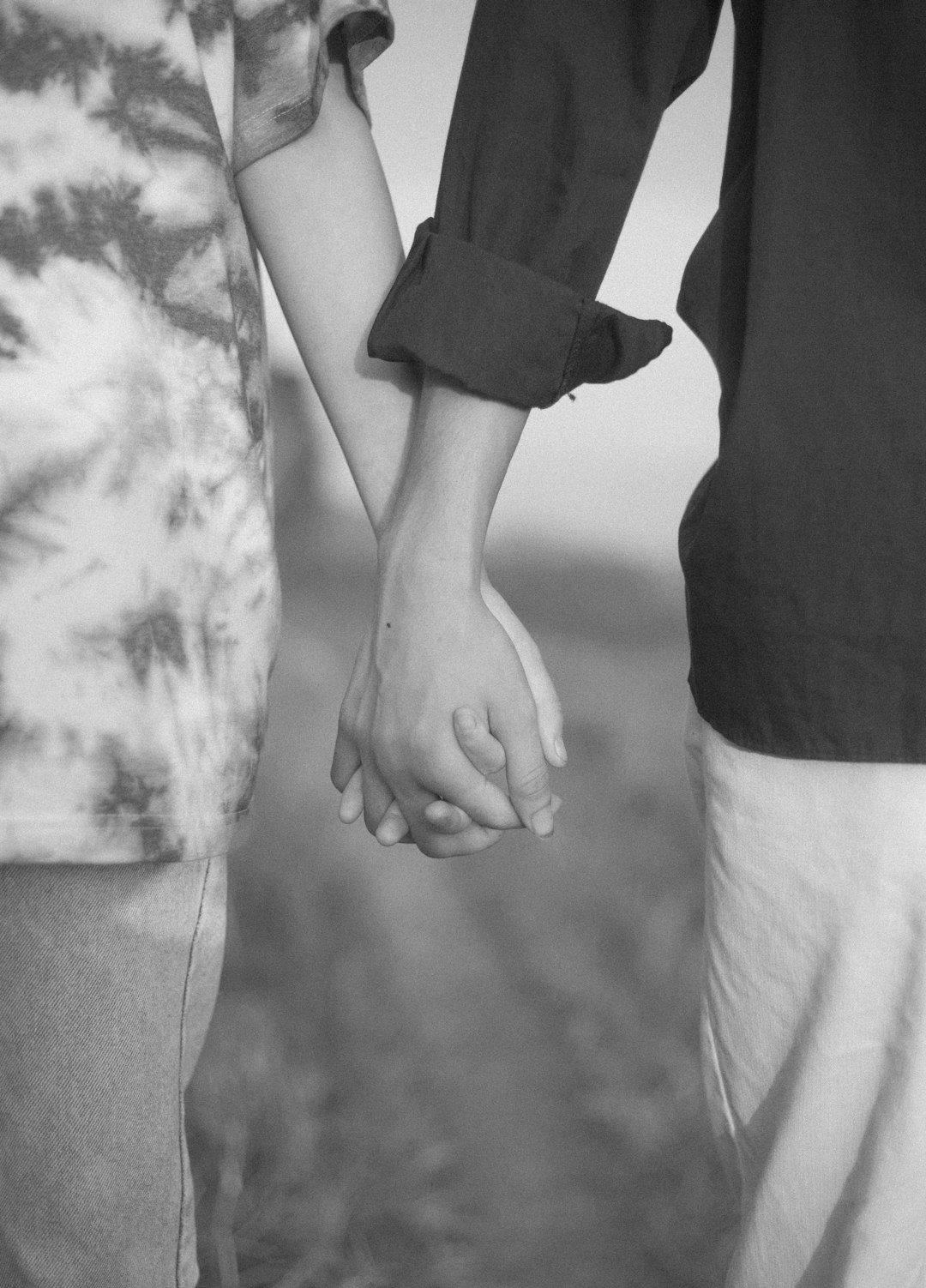 grayscale photo of couple holding hands