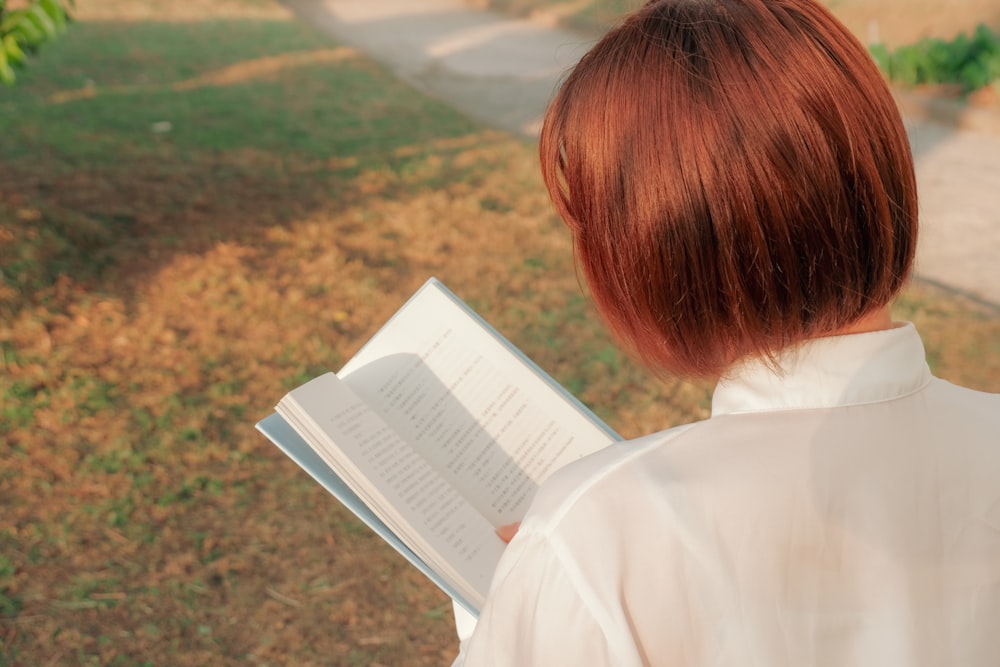 woman in white shirt reading book