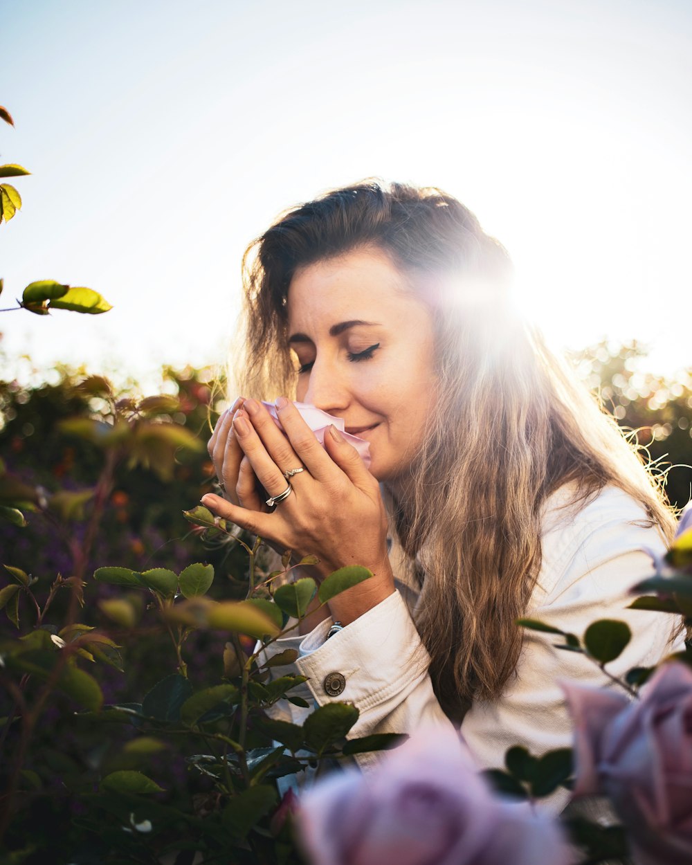 woman in white long sleeve shirt holding her face