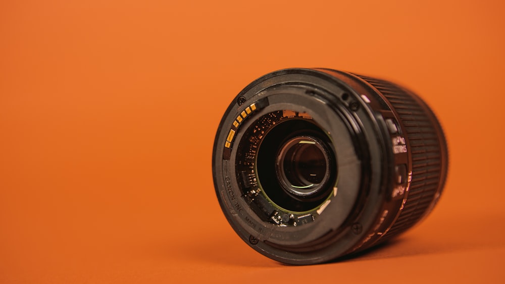 black camera lens on orange surface