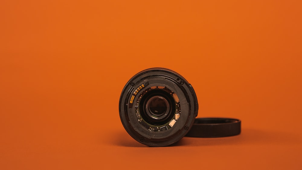 black camera lens on orange surface