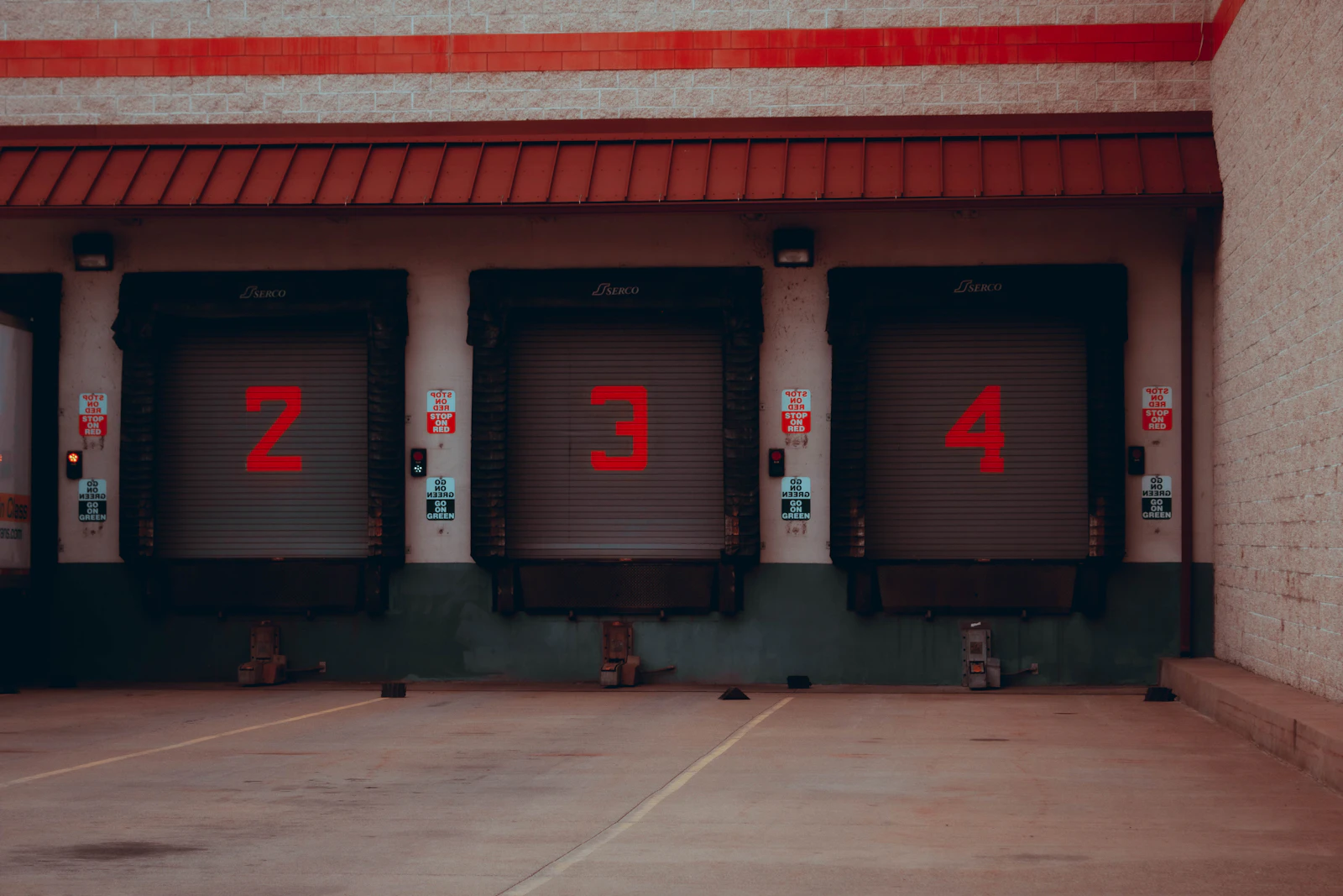 A red and white industrial building with loading bays