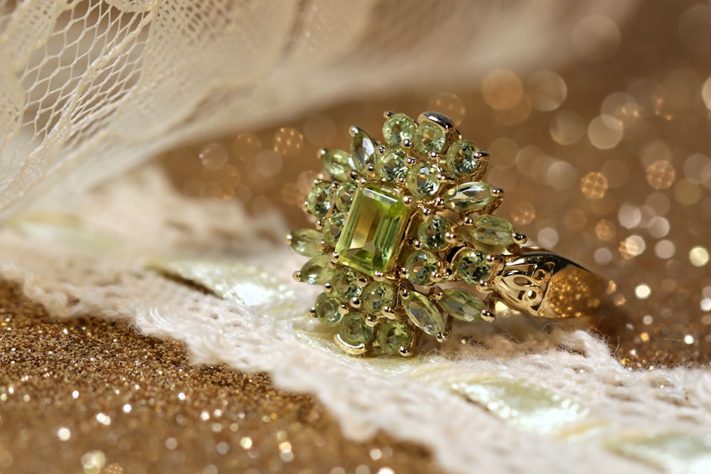 silver diamond studded ring on white textile