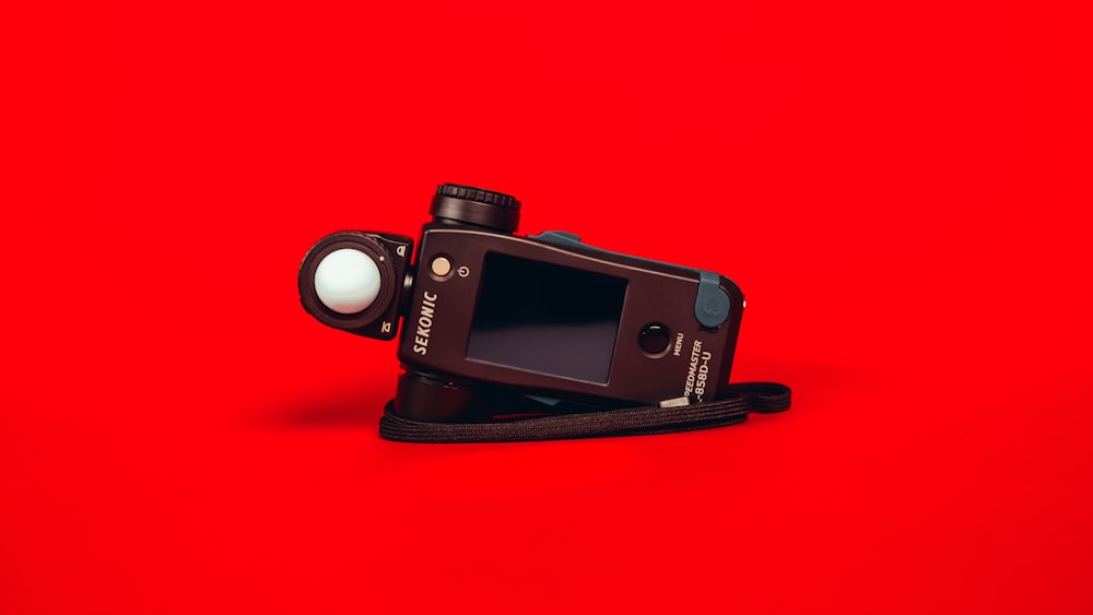 black nikon dslr camera on red surface