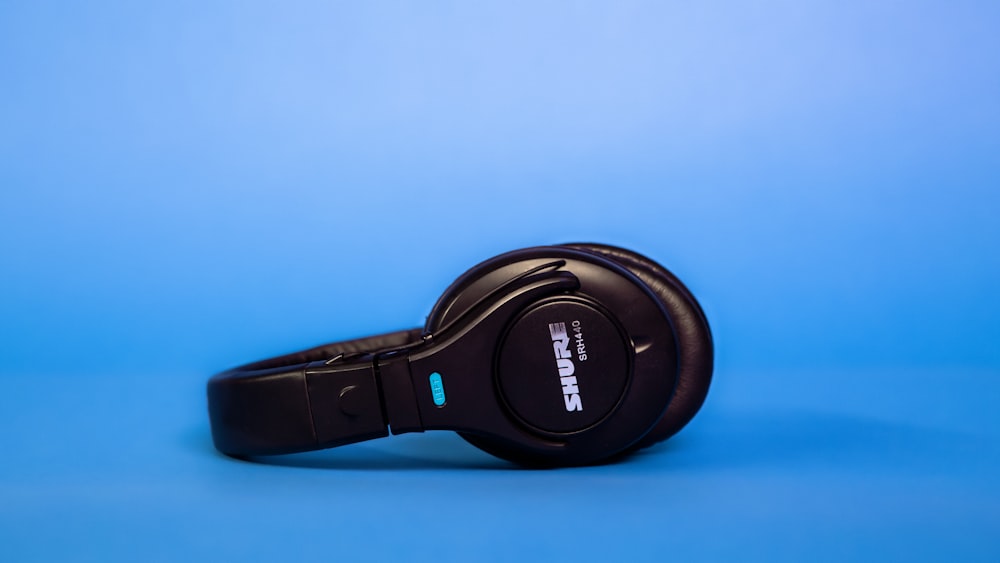 black sony headphones on blue surface
