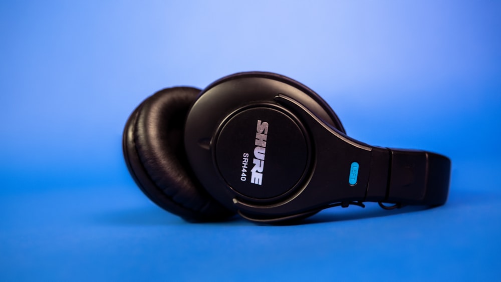 black sony headphones on blue surface