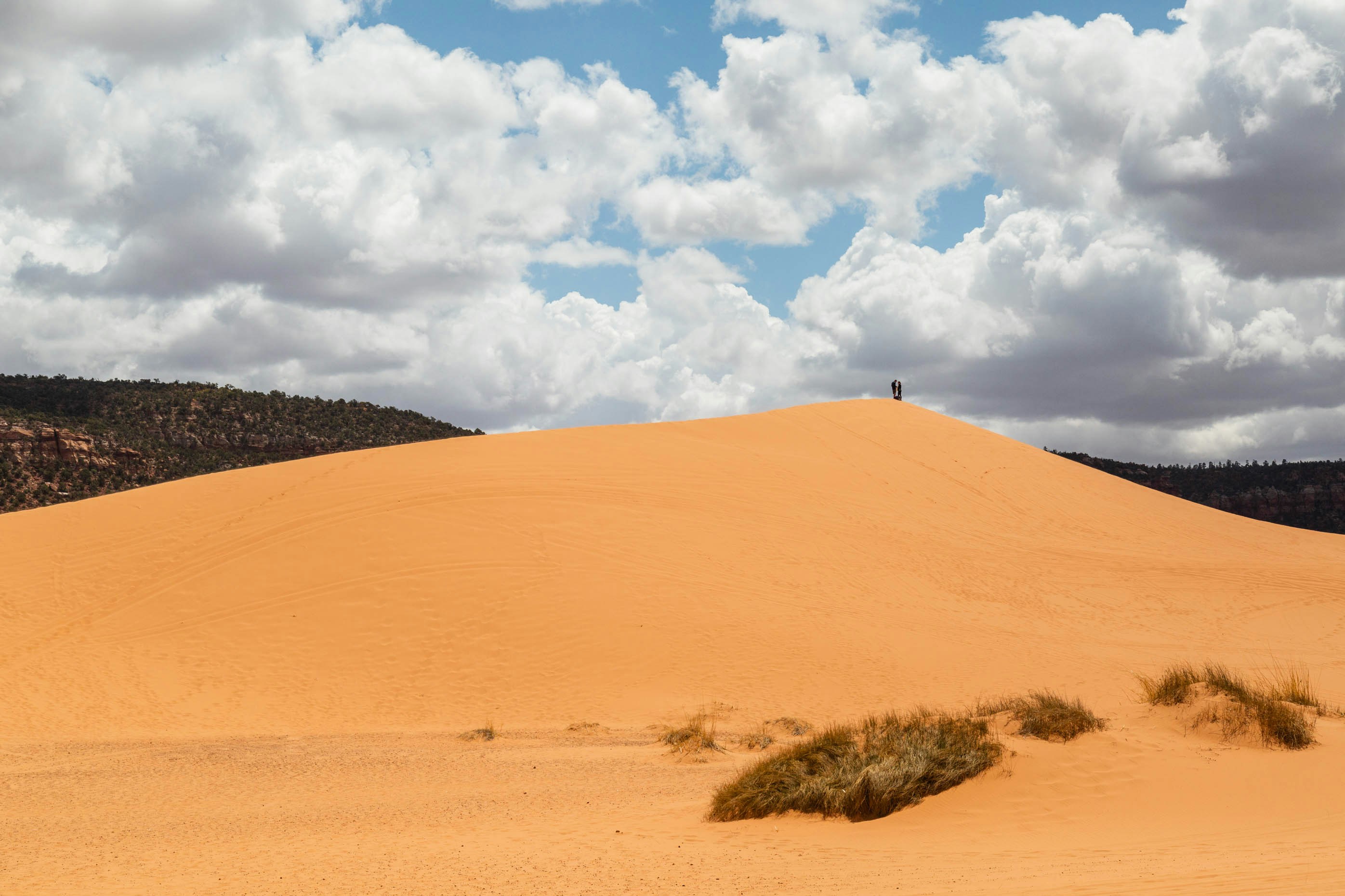 brown sand under white clouds and blue sky during daytime