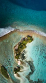 Aerial shot of a tropical island surrounded by turquoise waters.