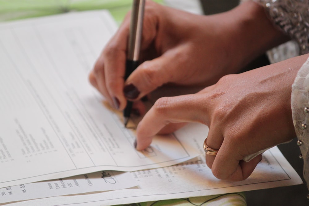 person writing on white paper