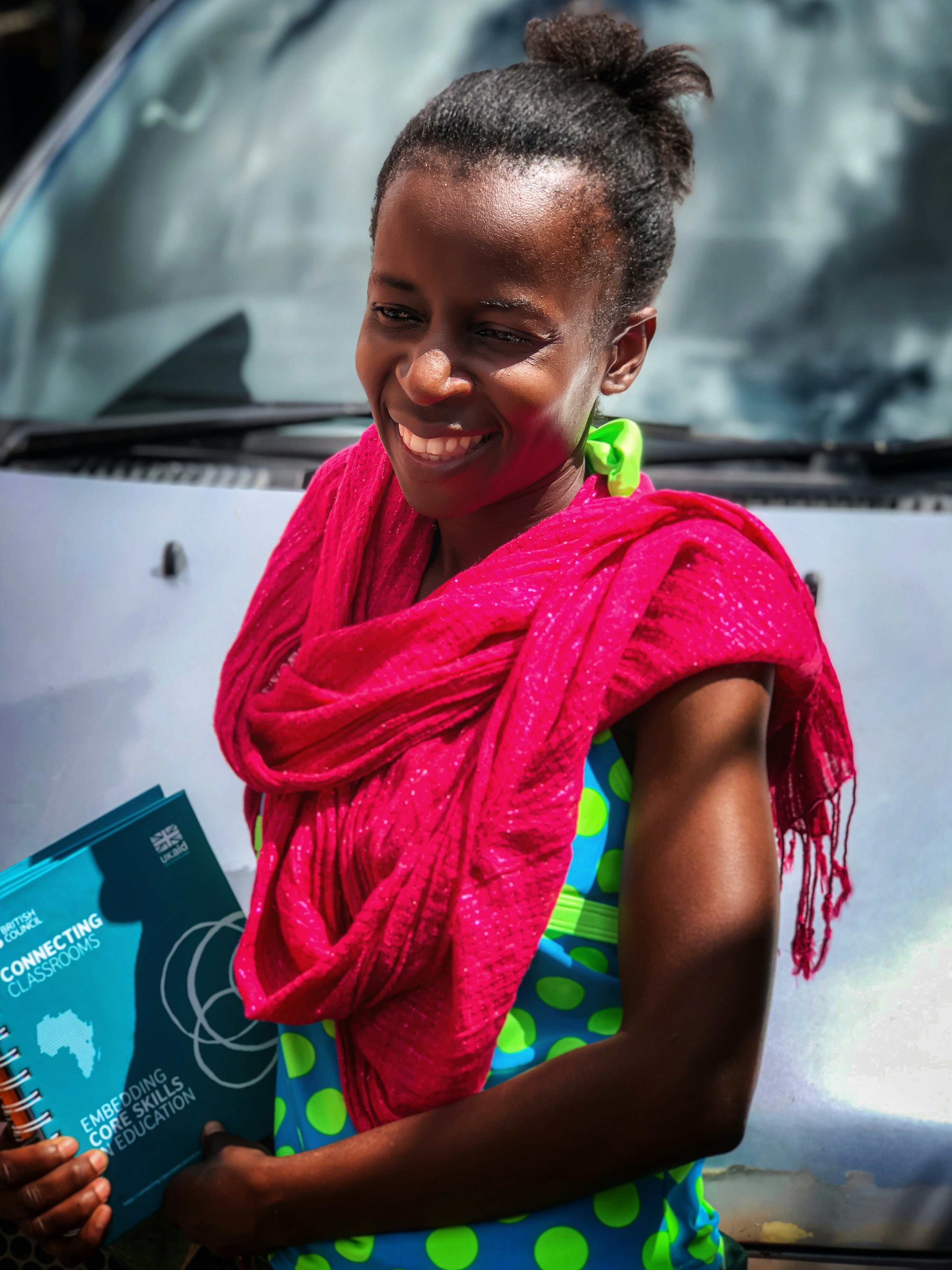 Niña sonriente en actividad de aprendizaje financiero con materiales didácticos coloridos