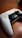 A gaming controller is placed on a wooden surface, featuring a sleek black and white design with prominent joysticks and buttons.