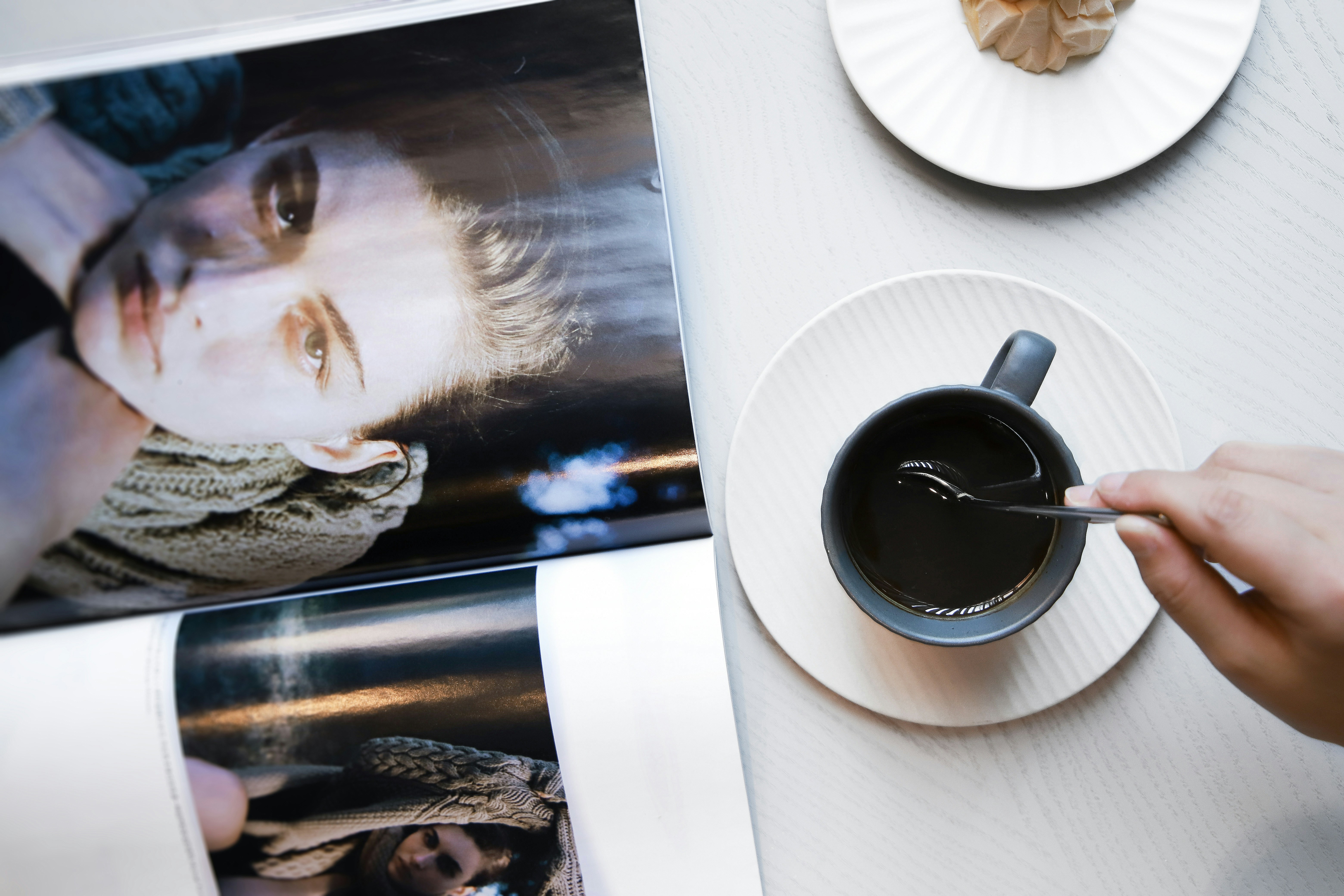 Mug keramik hitam di piring bundar putih