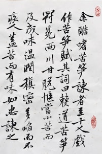Black ink calligraphy on white paper with characters arranged vertically. There are two red stamps that serve as artistic seals, one in the top right corner and another near the bottom right.