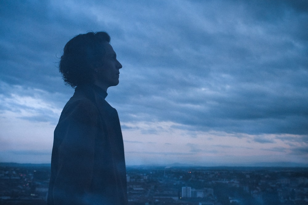 silhouette of woman standing on top of building during daytime