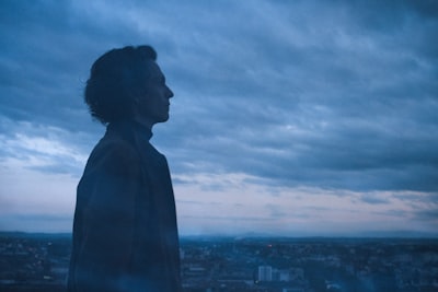 silhouette of woman standing on top of building during daytime visionary teams background