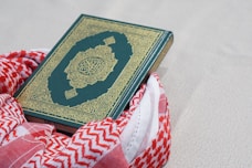 green and gold book on red and white textile