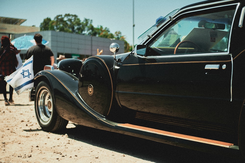 black classic car parked on gray concrete pavement during daytime