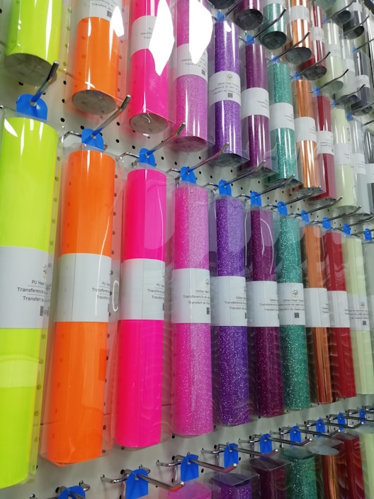 Close-up of colorful heat transfer vinyl sheets arranged neatly on a wooden table.
