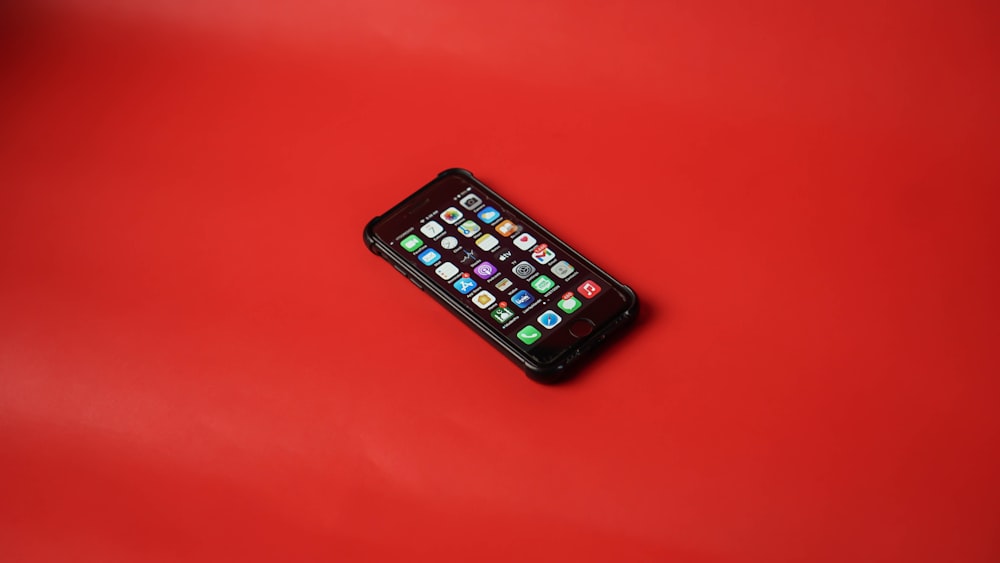 black iphone 5 on red surface