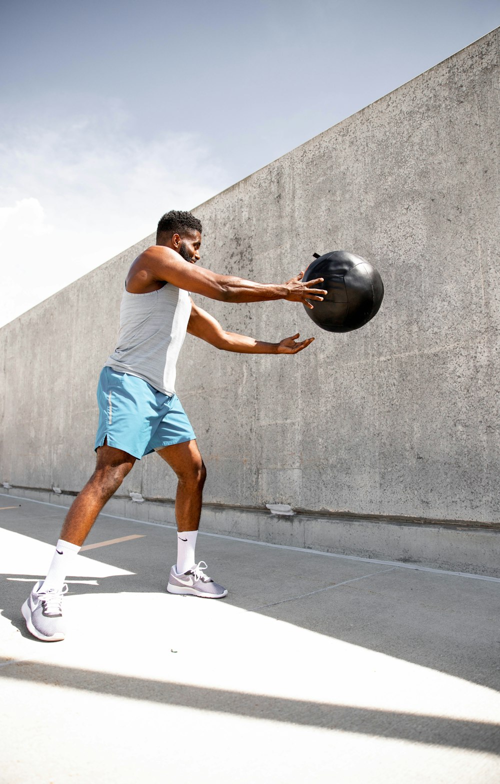 Hombre en ropa deportiva haciendo ejercicio con un balón medicinal crossfit  en un gimnasio