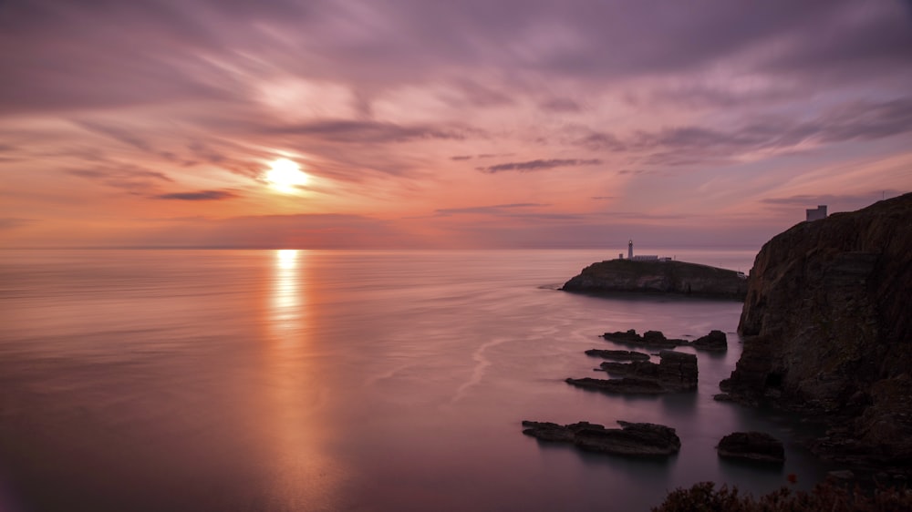 silhouette of boat on sea during sunset