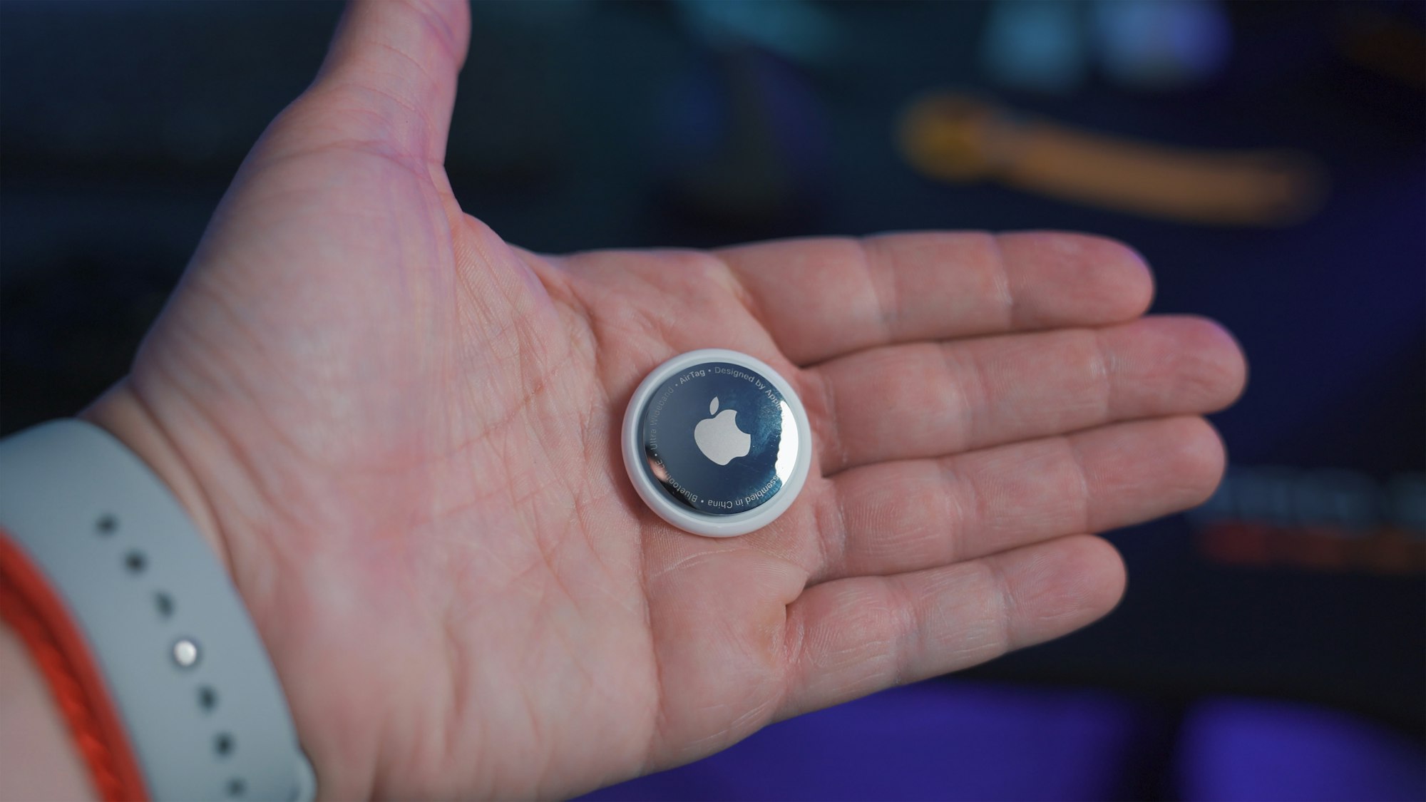 Young man holding Apple AirTag in hand