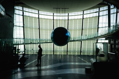 man in black jacket walking on gray floor