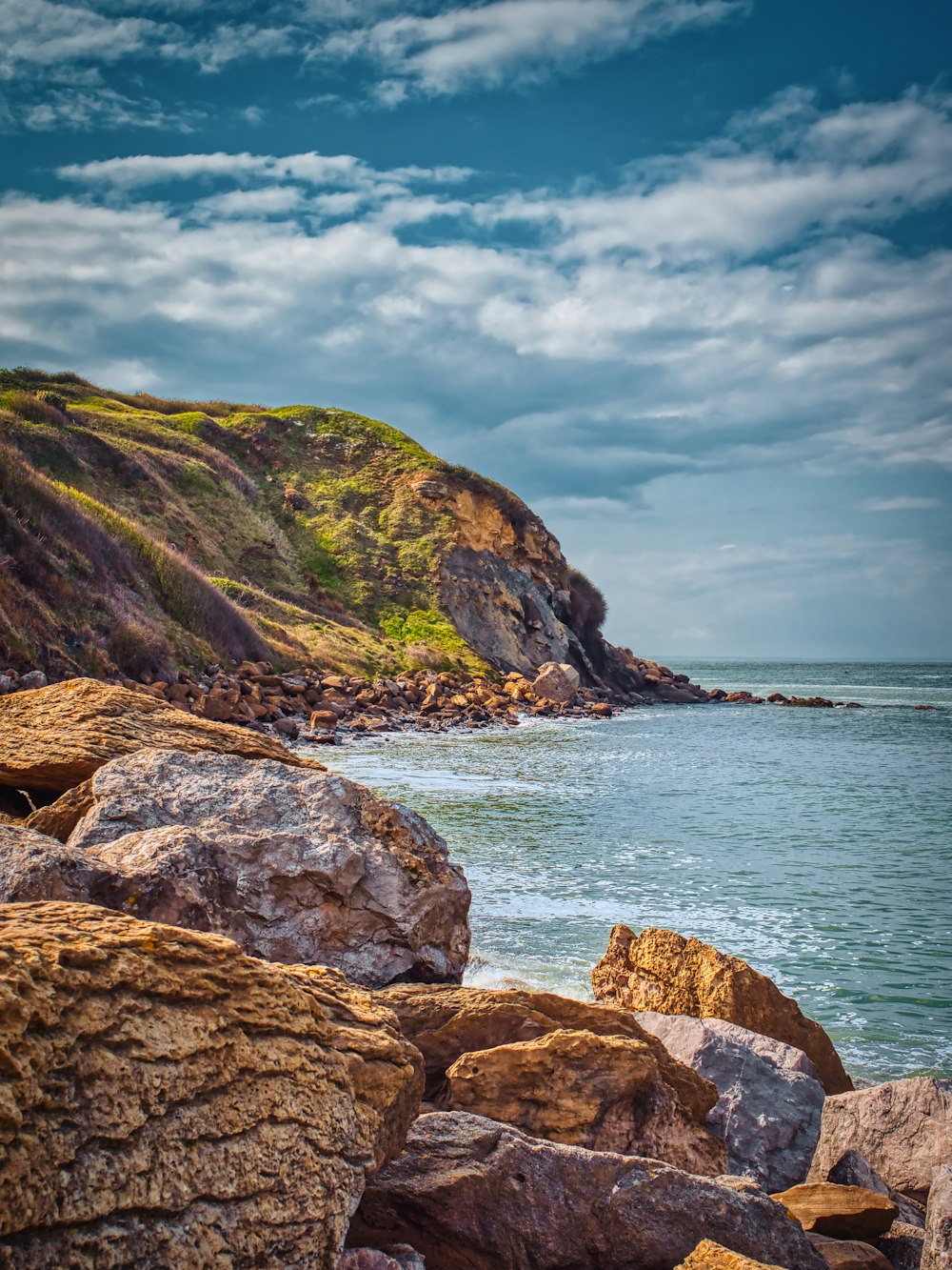 brown rock formation near body of water during daytime