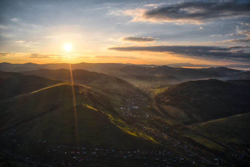 Breathtaking aerial view of a valley nestled between two majestic mountains at sunset