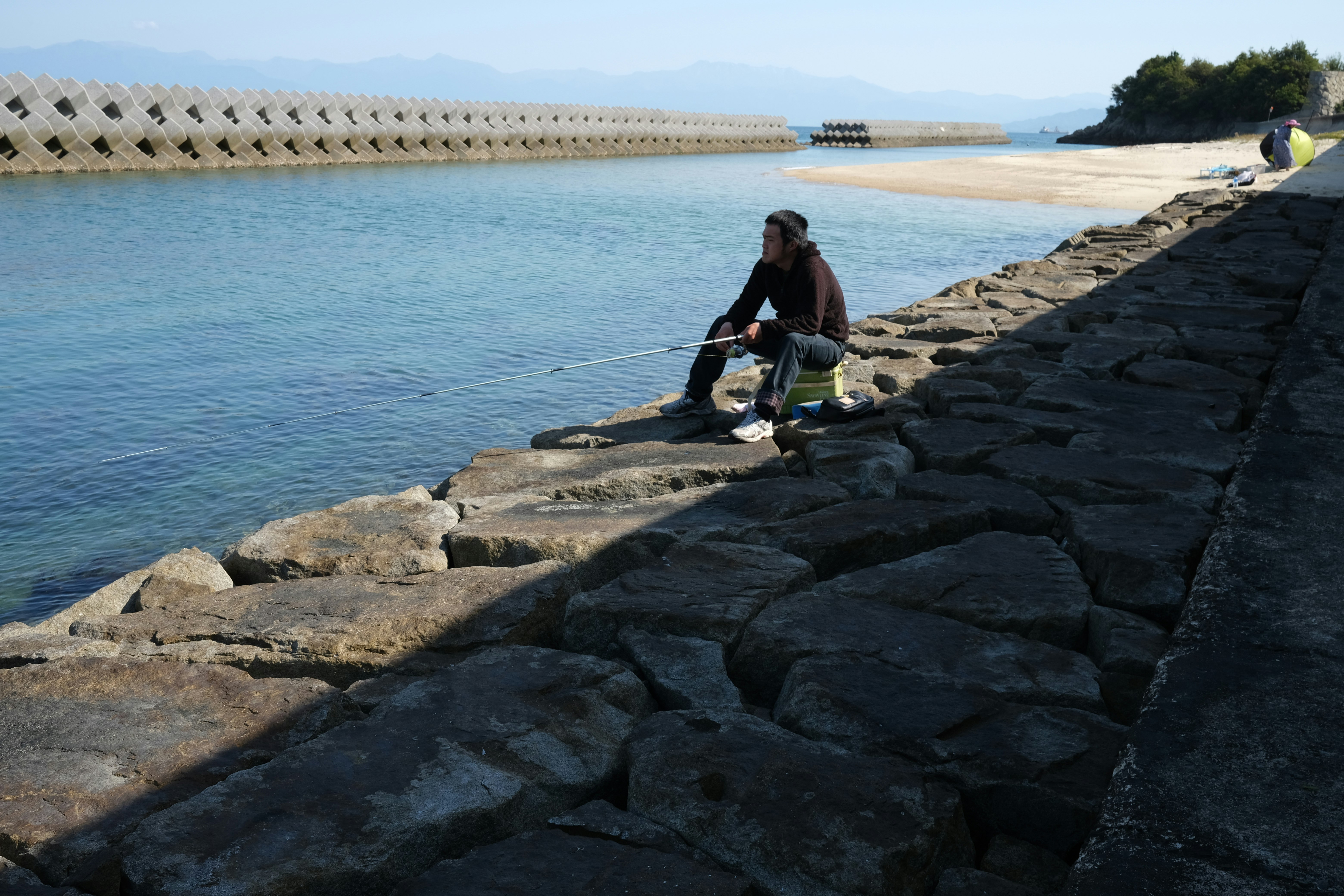 woman in black shirt and blue denim jeans standing on gray concrete dock during daytime