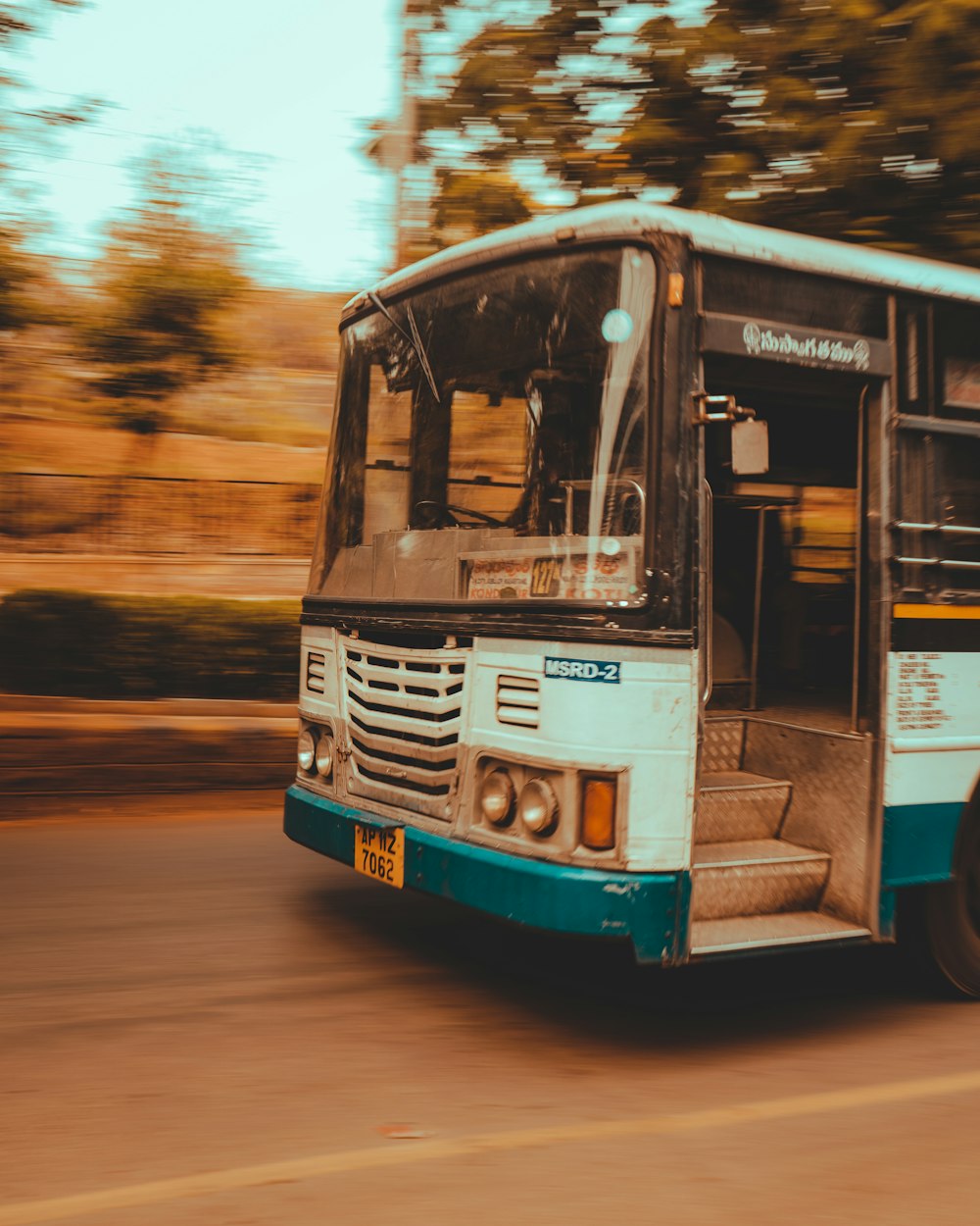 white and blue bus on road during daytime