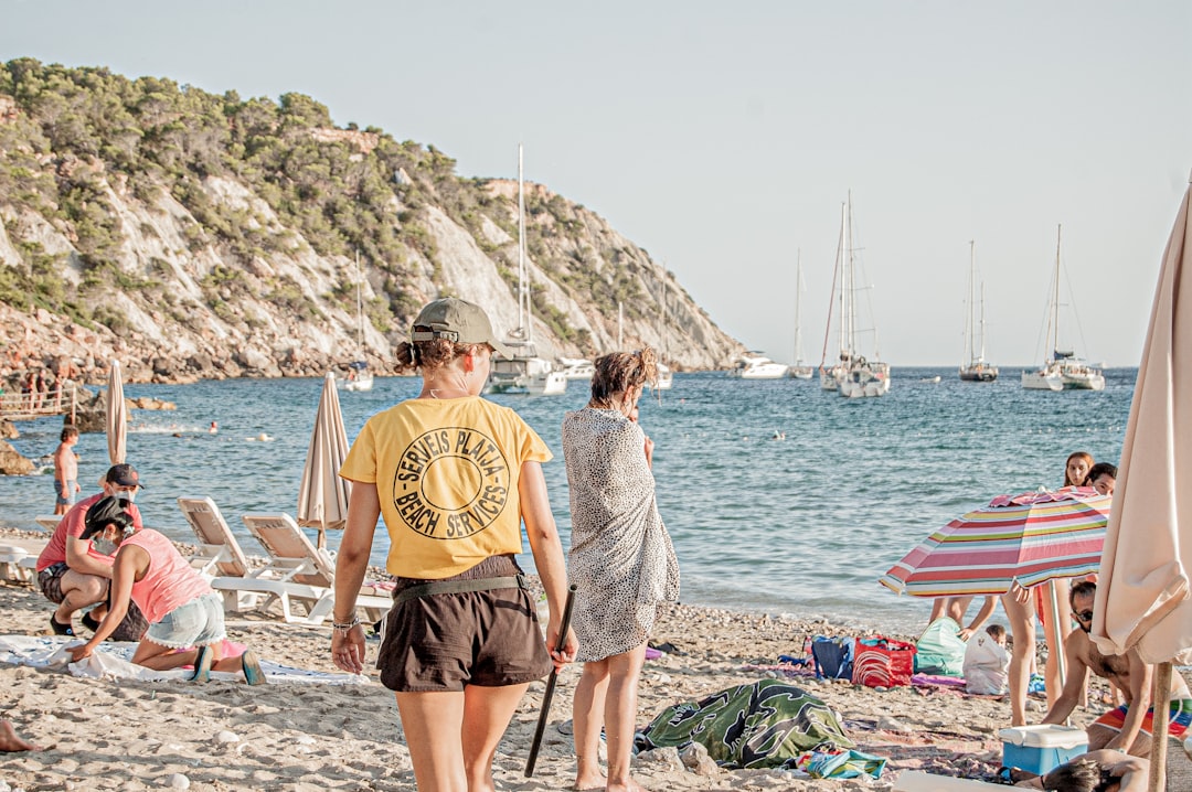 man and woman standing on beach during daytime