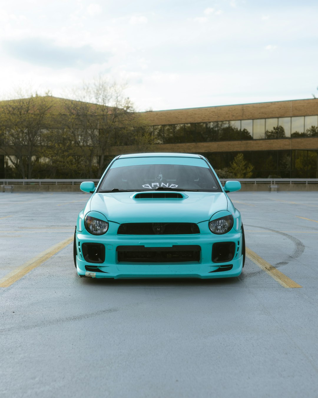 teal car on gray asphalt road during daytime