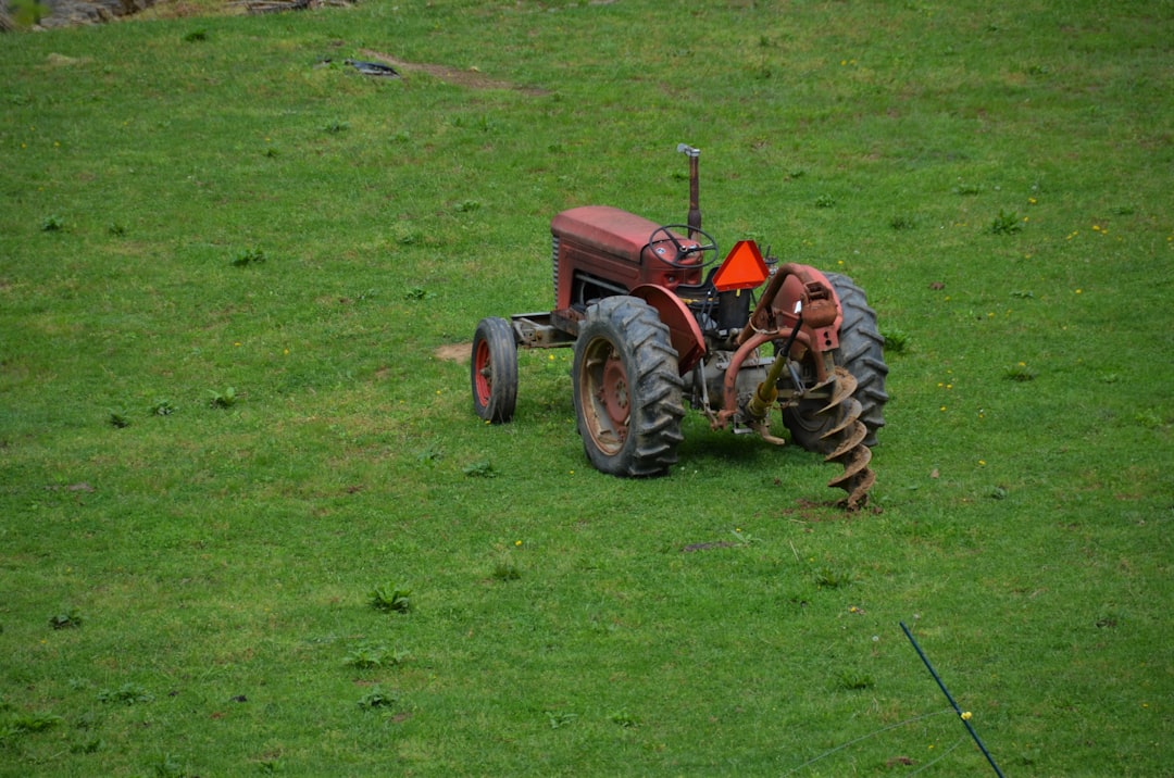 red tractor on green grass field during daytime