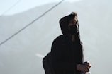 woman in black coat standing on snow covered ground during daytime