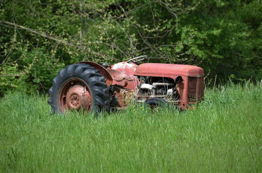 red tractor on green grass field during daytime