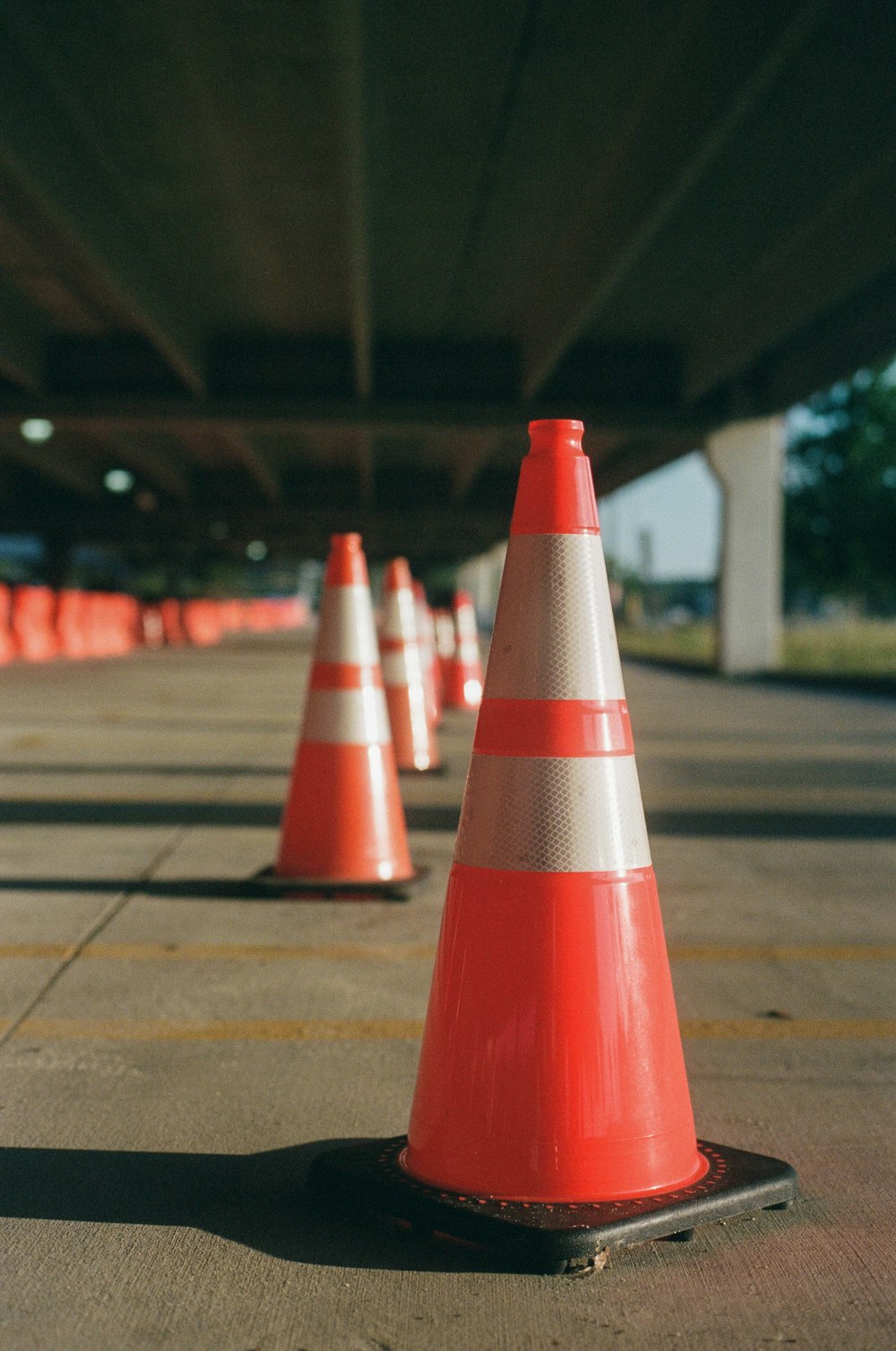 Cône de signalisation orange et blanc sur sol en béton gris