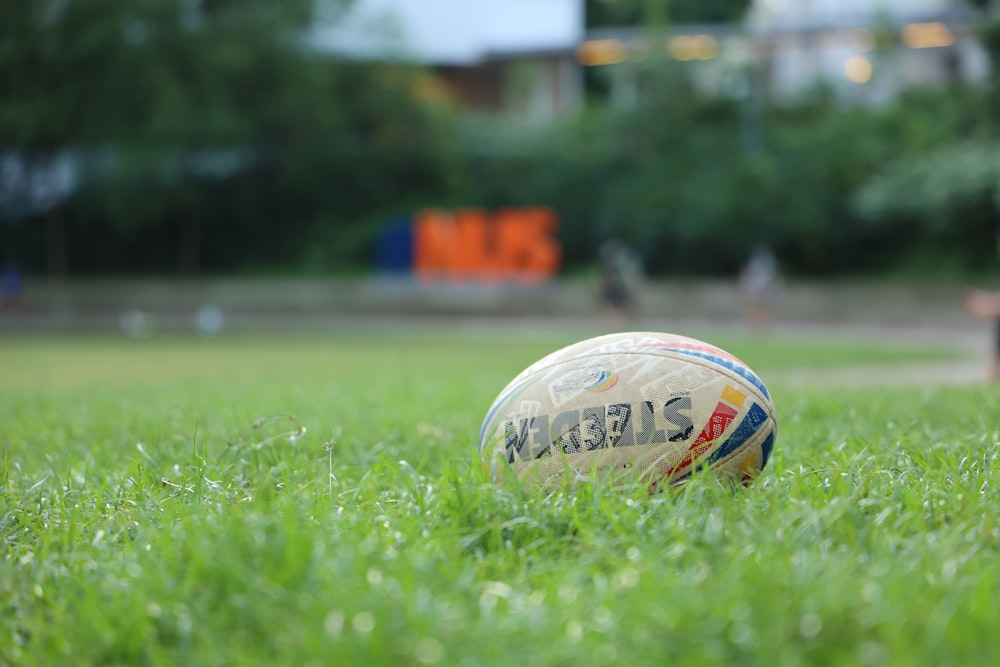 white and red soccer ball on green grass field during daytime