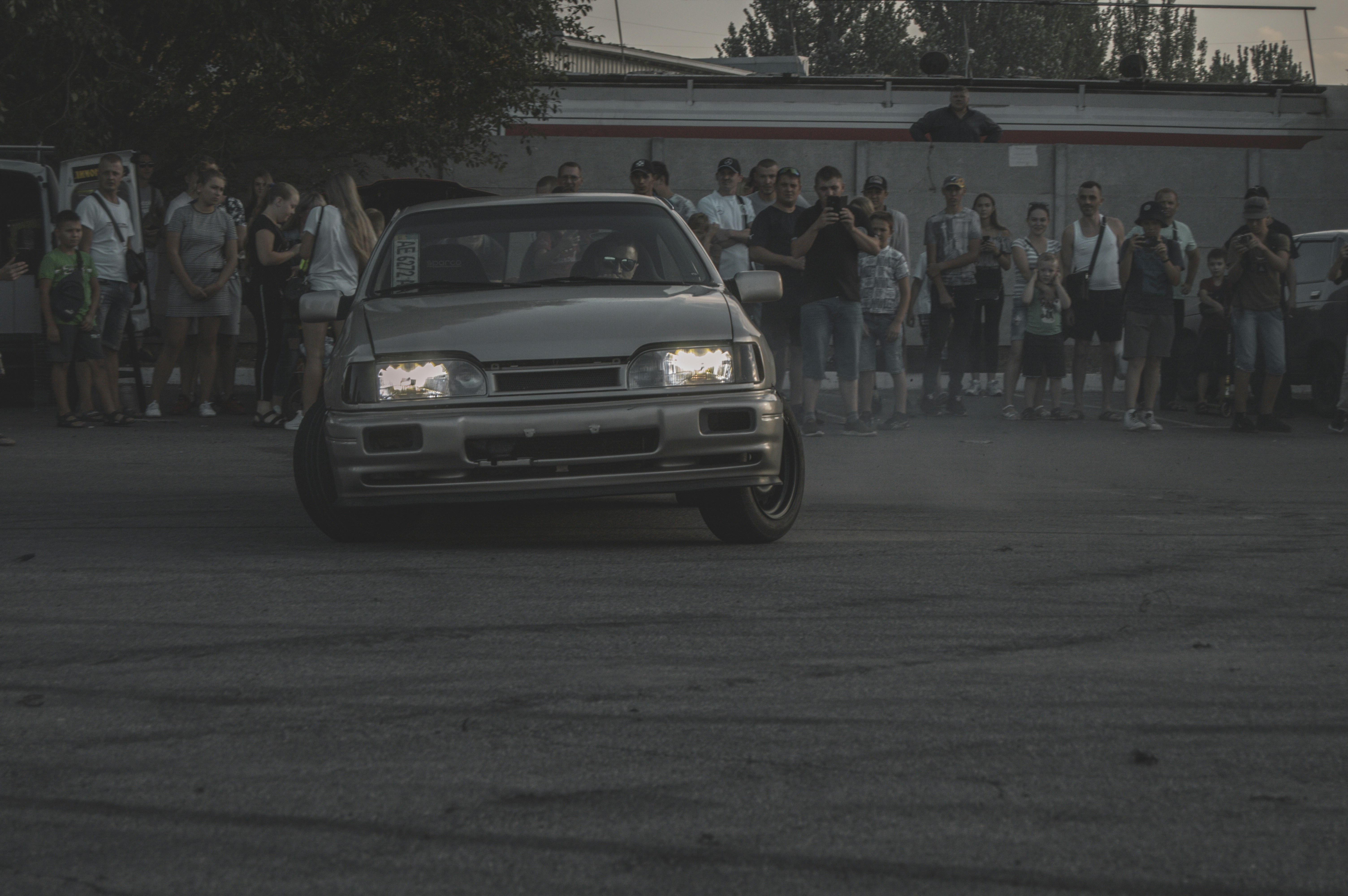 people standing near gray car during daytime