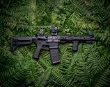 black rifle on green textile