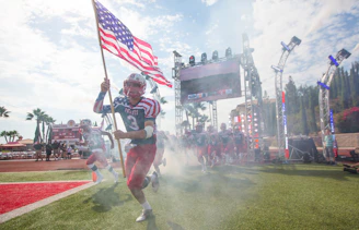 man in white and red jersey shirt holding flag of america